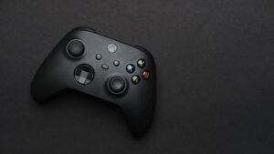 Closeup of a black gaming controller on a dark backdrop, perfect for tech themes.